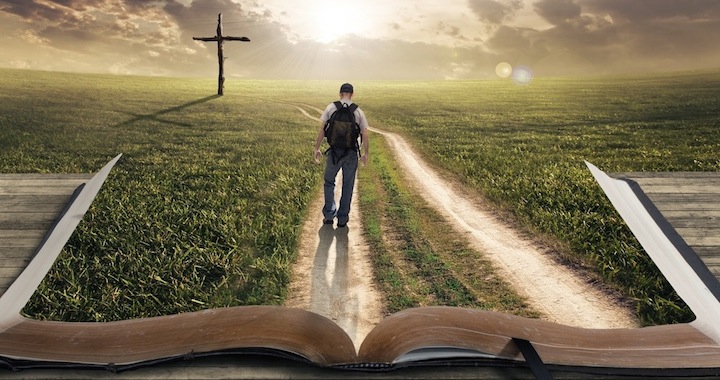man walking on the Bible towards a cross